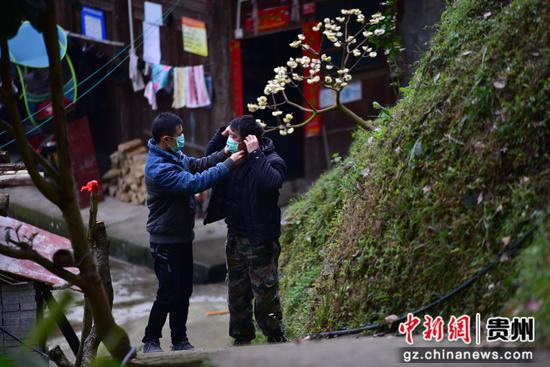 图为龙碧能(左)帮助父亲龙孝文(右)整理口罩,父子二人午饭过后继续投入到疫情防控工作中。 杨武魁 摄 图为龙碧能(左)帮助父亲龙孝文(右)整理口罩,父子二人午饭过后继续投入到疫情防控工作中。 杨武魁 摄