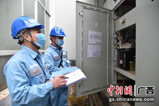 2月5日,南方电网广西来宾供电局工作人员黄光华、韦革查看德福特专变低压柜查看用电负荷情况 摄影 黄伊 2月5日,南方电网广西来宾供电局工作人员黄光华、韦革查看德福特专变低压柜查看用电负荷情况 摄影 黄伊