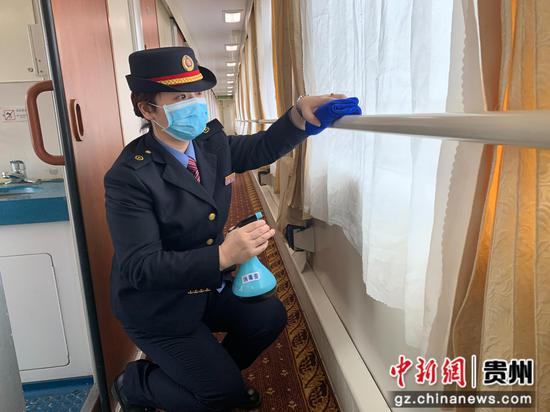 图为胡熏月正在对车厢走廊过道的栏杆消毒。 图为胡熏月正在对车厢走廊过道的栏杆消毒。