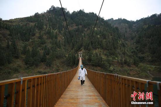 今年50岁的苗族村医龙光庆,是贵州省黔东南苗族侗族自治州丹寨县排调镇双尧村的村医。多年来,他要服务双尧村四个自然寨的1300多苗族村民,是村民眼中的“名医”。新冠肺炎疫情发生后,龙光庆更加地忙碌,每天都要爬山涉水十多公里穿梭于河两岸的苗寨中,给村民们测量体温、宣传防控知识等。他说:“作为一名村医,我就要尽自己的所能守护好村民的健康,这也是我学医以来一个最大的愿望。”图为2月7日,龙光庆行走在前往排尧苗寨的铁索桥上。中新社发 黄晓海 摄 今年50岁的苗族村医龙光庆,是贵州省黔东南苗族侗族自治州丹寨县排调镇双尧村的村医。多年来,他要服务双尧村四个自然寨的1300多苗族村民,是村民眼中的“名医”。新冠肺炎疫情发生后,龙光庆更加地忙碌,每天都要爬山涉水十多公里穿梭于河两岸的苗寨中,给村民们测量体温、宣传防控知识等。他说:“作为一名村医,我就要尽自己的所能守护好村民的健康,这也是我学医以来一个最大的愿望。”图为2月7日,龙光庆行走在前往排尧苗寨的铁索桥上。中新社发 黄晓海 摄