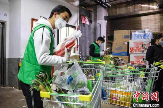 图为超市工作人员为顾客配货。 瞿宏伦 摄 图为超市工作人员为顾客配货。 瞿宏伦 摄
