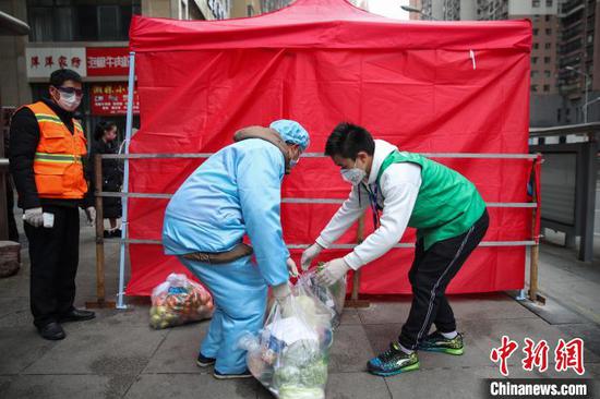 图为配送人员把商品送至小区指定收取区域。 瞿宏伦 摄 图为配送人员把商品送至小区指定收取区域。 瞿宏伦 摄