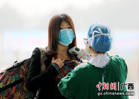 2月11日,在钦州火车东站进站口,医务人员对进站旅客检测体温。曾开宏 摄 2月11日,在钦州火车东站进站口,医务人员对进站旅客检测体温。曾开宏 摄