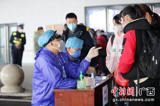 2月11日,防控人员在钦州东站出站口对抵钦人员进行登记。曾开宏 摄 2月11日,防控人员在钦州东站出站口对抵钦人员进行登记。曾开宏 摄