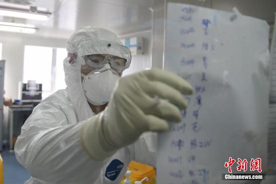 2月13日,贵州省人民医院检验科检测人员在张贴送检样本信息。作为贵州省21家新冠肺炎核酸定点检测机构之一,该医院检验科10名检测人员分成三组,每天24小时轮班倒,不间断地进行检测。现医院每日检测量为100至200例,能实现当日采样当日送检。中新社记者 瞿宏伦 摄 2月13日,贵州省人民医院检验科检测人员在张贴送检样本信息。作为贵州省21家新冠肺炎核酸定点检测机构之一,该医院检验科10名检测人员分成三组,每天24小时轮班倒,不间断地进行检测。现医院每日检测量为100至200例,能实现当日采样当日送检。中新社记者 瞿宏伦 摄