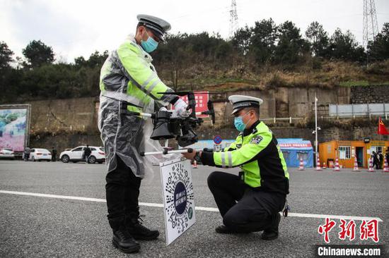 两名交警在无人机上悬挂二维码。 瞿宏伦 摄 两名交警在无人机上悬挂二维码。 瞿宏伦 摄
