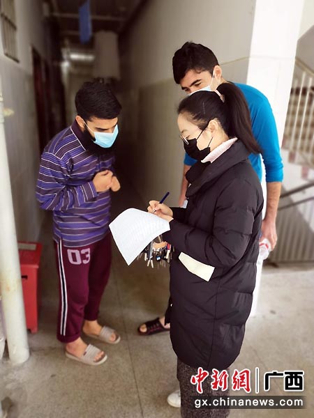 图为李汇哲给留学生测量体温。南师宣 摄 图为李汇哲给留学生测量体温。南师宣 摄