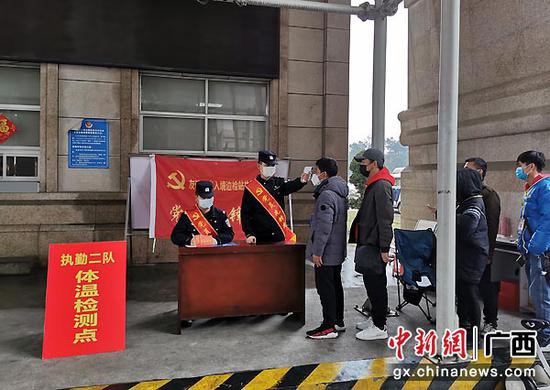 图为友谊关边检站民警在检测体温。 图为友谊关边检站民警在检测体温。