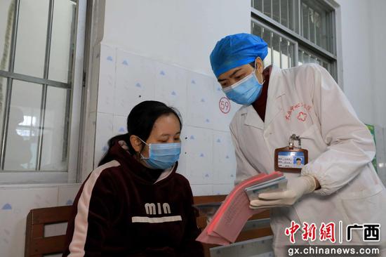 韦柳香（右）为就诊患者讲解疫情防控知识。谭凯兴 摄