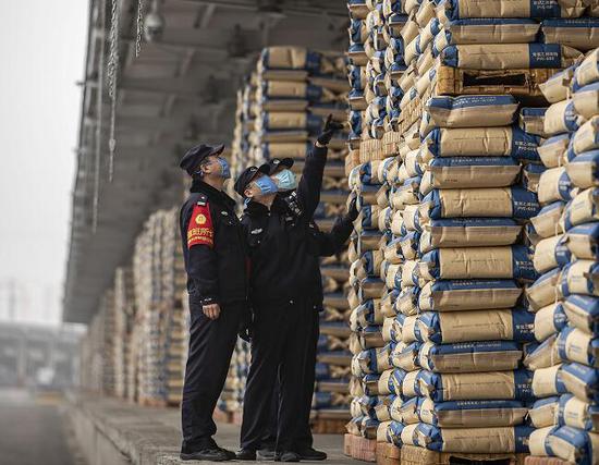 图为27日民警对货场进行安全巡查，并对进入货场司机进行安全提示。