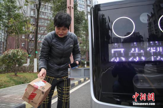 2月26日,一位市民从配送机器人的快递箱中取走货物。京东物流日前在贵阳市观山湖区观山小区投用了智能配送机器人,实现了“无接触送货”。据悉,该配送机器人无人操控,能够自主规避障碍和往来的车辆、行人,并准确将货物送达目的地。 中新社记者 瞿宏伦 摄 2月26日,一位市民从配送机器人的快递箱中取走货物。京东物流日前在贵阳市观山湖区观山小区投用了智能配送机器人,实现了“无接触送货”。据悉,该配送机器人无人操控,能够自主规避障碍和往来的车辆、行人,并准确将货物送达目的地。 中新社记者 瞿宏伦 摄