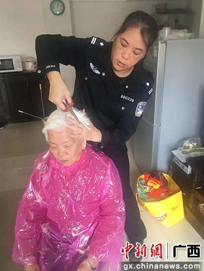 范丽萍抽空为母亲修剪头发。