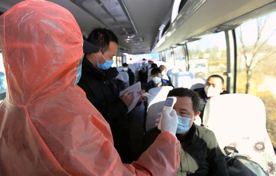圖為工作人員對返崗復工人員進行體溫監測。王前喜 攝 圖為工作人員對返崗復工人員進行體溫監測。王前喜 攝