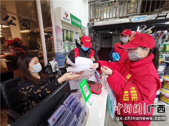 在南宁蟠龙社区，志愿者给沿街店铺市民派发爱心口罩