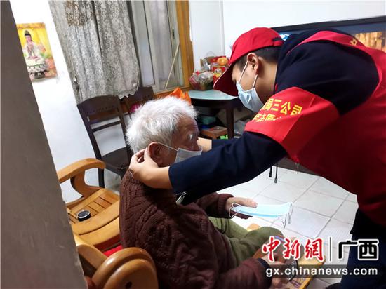 在柳州跃进小区，志愿者入户给孤寡老人戴上口罩