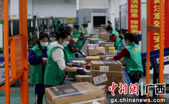 工作人员正在忙碌地分拣包裹。覃庆和 摄 工作人员正在忙碌地分拣包裹。覃庆和 摄