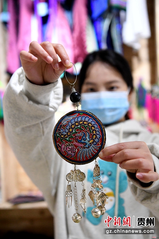 3月18日,在贵州省榕江县卧龙移民安置小区,一位姑娘在扶贫车间里展示刺绣作品。王炳真 摄 3月18日,在贵州省榕江县卧龙移民安置小区,一位姑娘在扶贫车间里展示刺绣作品。王炳真 摄