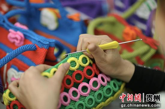 贵州赤水市长期镇康桥社区，一名妇女在“扶贫车间”钩织产品。