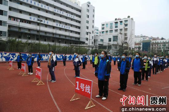 走读管理的贵州省凯里市第四中学九年级的学生,其间保持1米距离,列队