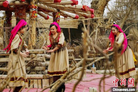 罗布人村寨景区里的人们为游客献上做饭舞。　庞博 摄
