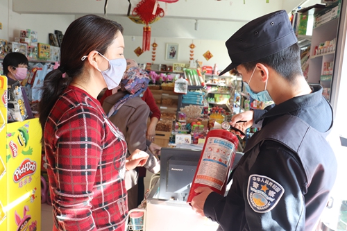 民警正在检查超市灭火器是否过期。石晓坤 摄
