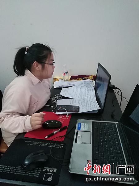 图为贺州市钟山县第二高级中学陈思宇同学直播前在整理作品讲解资料。