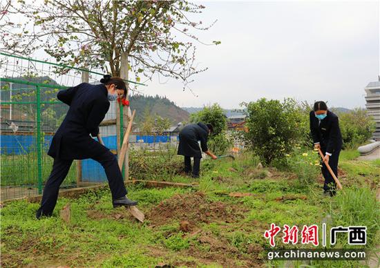 三江南站職工對小菜園進行翻土。李潔 攝 三江南站職工對小菜園進行翻土。李潔 攝