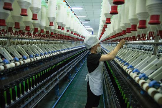 4月15日上午,在新疆洛浦县汇联丰纺织有限公司生产厂里,细纱挡车工