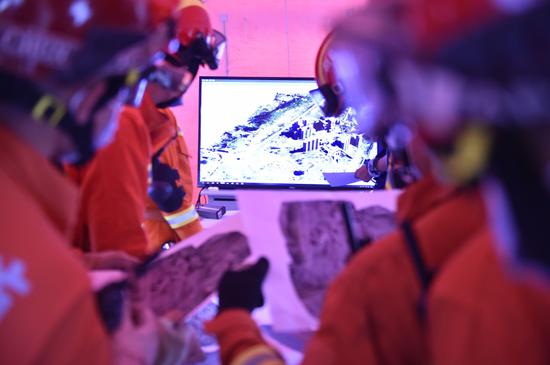 图为消防救援人员通过5g传回的视频查看模拟地震的现场情况。 图为消防救援人员通过5g传回的视频查看模拟地震的现场情况。