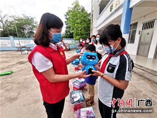 志愿者为孩子们送上可爱的蓝宝。关喆琳
摄 志愿者为孩子们送上可爱的蓝宝。关喆琳
摄