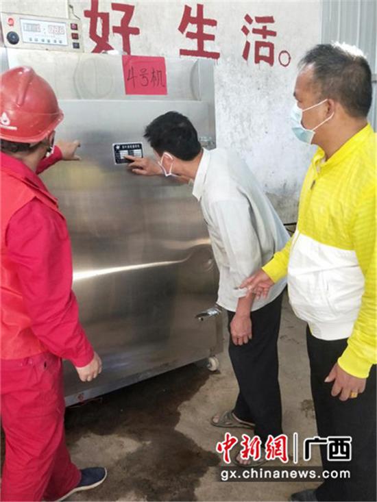 南方电网广西崇左市公司工作人员和拾义村村干部查看茶叶加工设备。许乐兴 摄 南方电网广西崇左市公司工作人员和拾义村村干部查看茶叶加工设备。许乐兴 摄