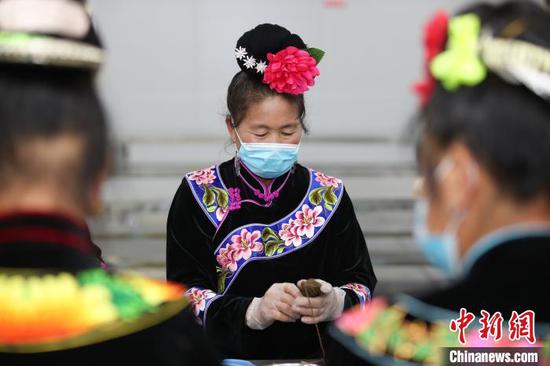 一位苗族妇女在包五彩粽。 瞿宏伦 摄 一位苗族妇女在包五彩粽。 瞿宏伦 摄