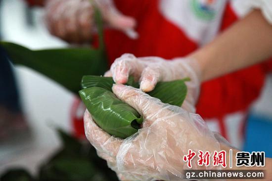 2020年6月24日,贵州省毕节市黔西县洪水镇洪水小学,老师教学生包粽子。史开心 摄 2020年6月24日,贵州省毕节市黔西县洪水镇洪水小学,老师教学生包粽子。史开心 摄