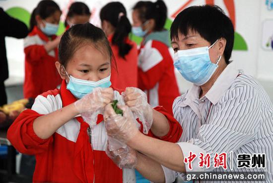 2020年6月24日,贵州省毕节市黔西县洪水镇洪水小学,教师教学生包粽子。I史开心 摄 2020年6月24日,贵州省毕节市黔西县洪水镇洪水小学,教师教学生包粽子。I史开心 摄