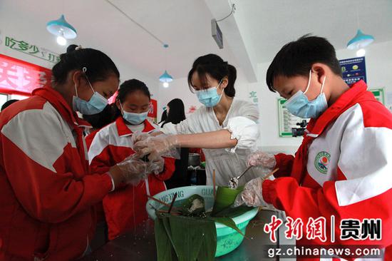 2020年6月24日,贵州省毕节市黔西县洪水镇洪水小学,教师教学生包粽子,并讲解端午节的故事。史开心 摄 2020年6月24日,贵州省毕节市黔西县洪水镇洪水小学,教师教学生包粽子,并讲解端午节的故事。史开心 摄