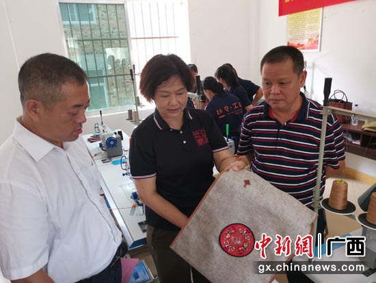 广西金壮锦文化艺术有限公司董事长贺卡向南宁市青秀区人民政府副区长孙凯(左一)展示学员作品成果。 广西金壮锦文化艺术有限公司董事长贺卡向南宁市青秀区人民政府副区长孙凯(左一)展示学员作品成果。
