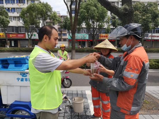 城管义工将凉茶送给环卫工人.陈泽州 摄