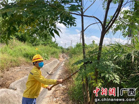 铁路职工正在对侵入铁路限界的树木进行砍伐。张成毅 摄 铁路职工正在对侵入铁路限界的树木进行砍伐。张成毅 摄