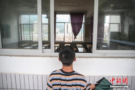 一名考生在眺望考场座位安排,因疫情防控考场不允许考生进入。 瞿宏伦 摄 一名考生在眺望考场座位安排,因疫情防控考场不允许考生进入。 瞿宏伦 摄