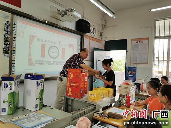 图为沛鸿中学老师给靠三考生发牛奶等具食品,寓意“牛气冲天”。河海夷 摄