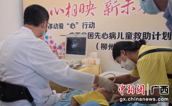 天津泰达国际心血管病医院的医生正在为柳州的贫困先心病患儿做B超筛查。 陈田 摄 天津泰达国际心血管病医院的医生正在为柳州的贫困先心病患儿做B超筛查。 陈田 摄