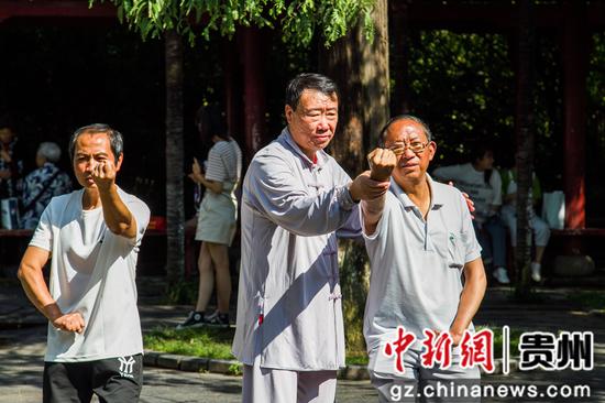 谢肇兴（中）在贵州省毕节市人民公园里指导市民练拳。