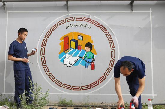 图为消防员在“消防主题文化桥”前合影留念。 图为消防员在“消防主题文化桥”前合影留念。