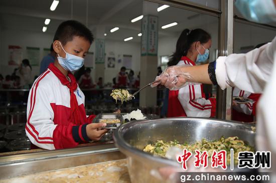 贵州毕节七星关区朱昌小学学生在打餐。