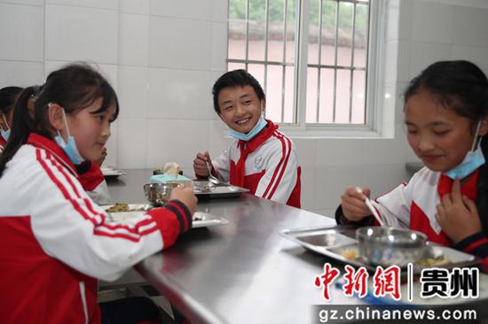 贵州毕节七星关区朱昌小学学生在吃营养午餐。