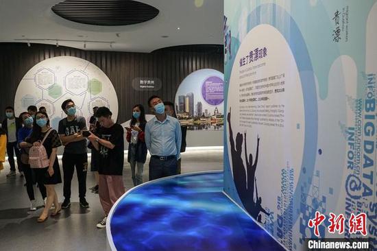 图为6月13日，参观者在国家大数据(贵州)综合试验区展示中心观看“贵漂”介绍展板。 中新社记者 瞿宏伦 摄
