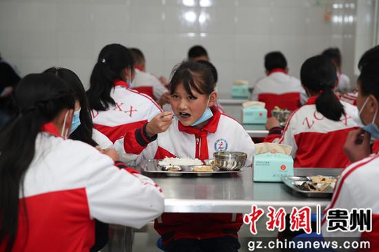 贵州毕节七星关区朱昌小学学生在吃营养午餐。