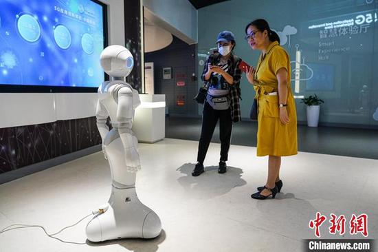 图为6月13日，参观者在国家大数据(贵州)综合试验区展示中心和5G智能机器人互动。 中新社记者 瞿宏伦 摄