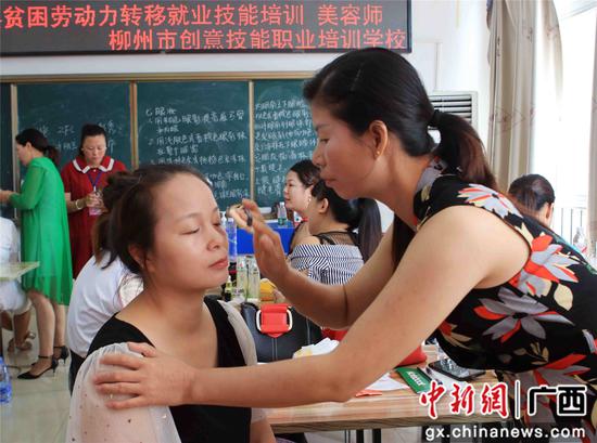 图八:7月28日,在2020年融安县贫困劳动力转移就业技能培训班上,贫困群众学习化妆。刘梁春 摄