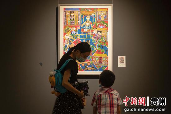 图为家长带着孩子观看展览。 郎洁曲珍 摄
